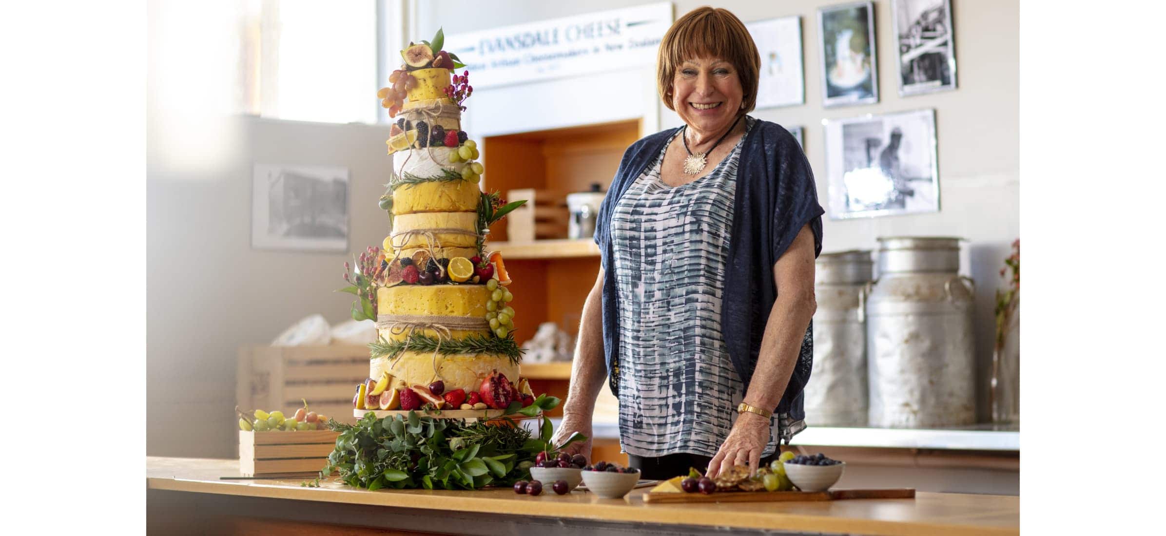 Colleen displays her example of a wedding cheese cake made by towering layers of circular cheese blocks.